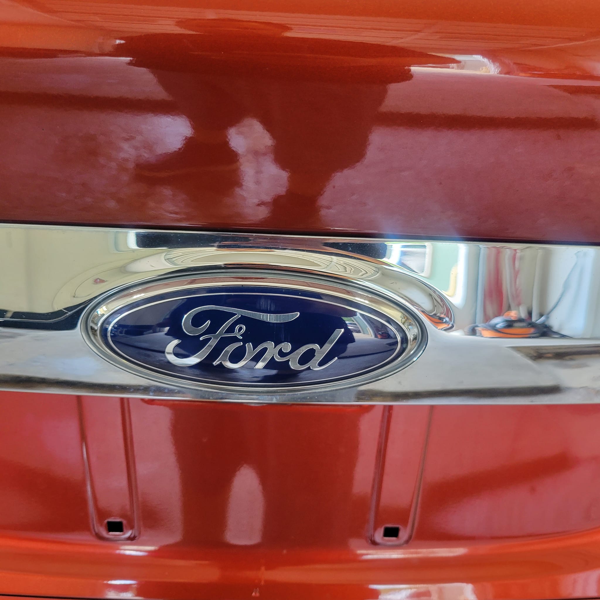 Polished Ford emblem on red vehicle
